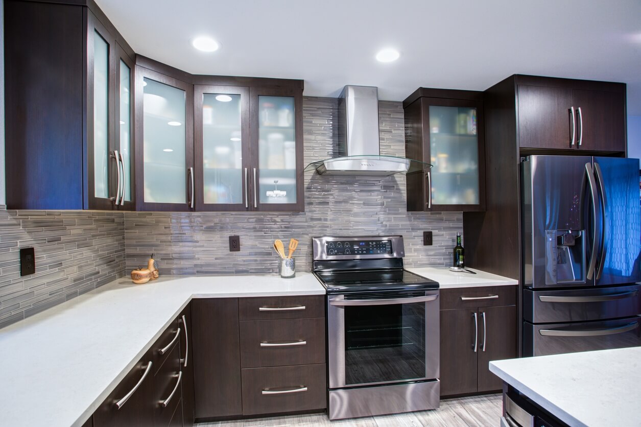 Kitchen with brown cabinets, glass fronts, and white countertops