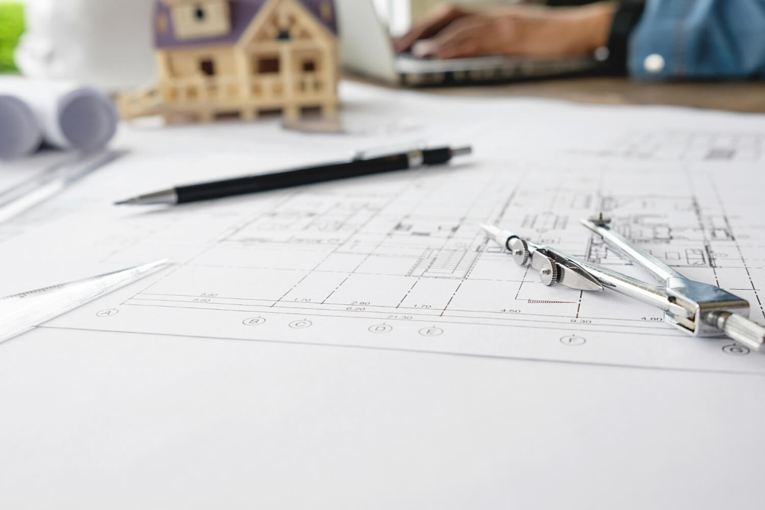 Construction plans laid out on table agreement signing meeting custom built design and remodeling
