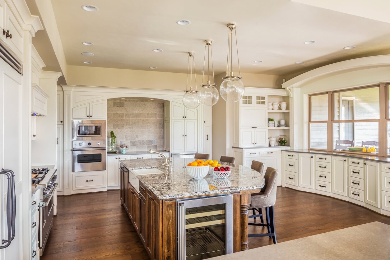 Remodeled kitchen space with hardwood floors and white cabinets