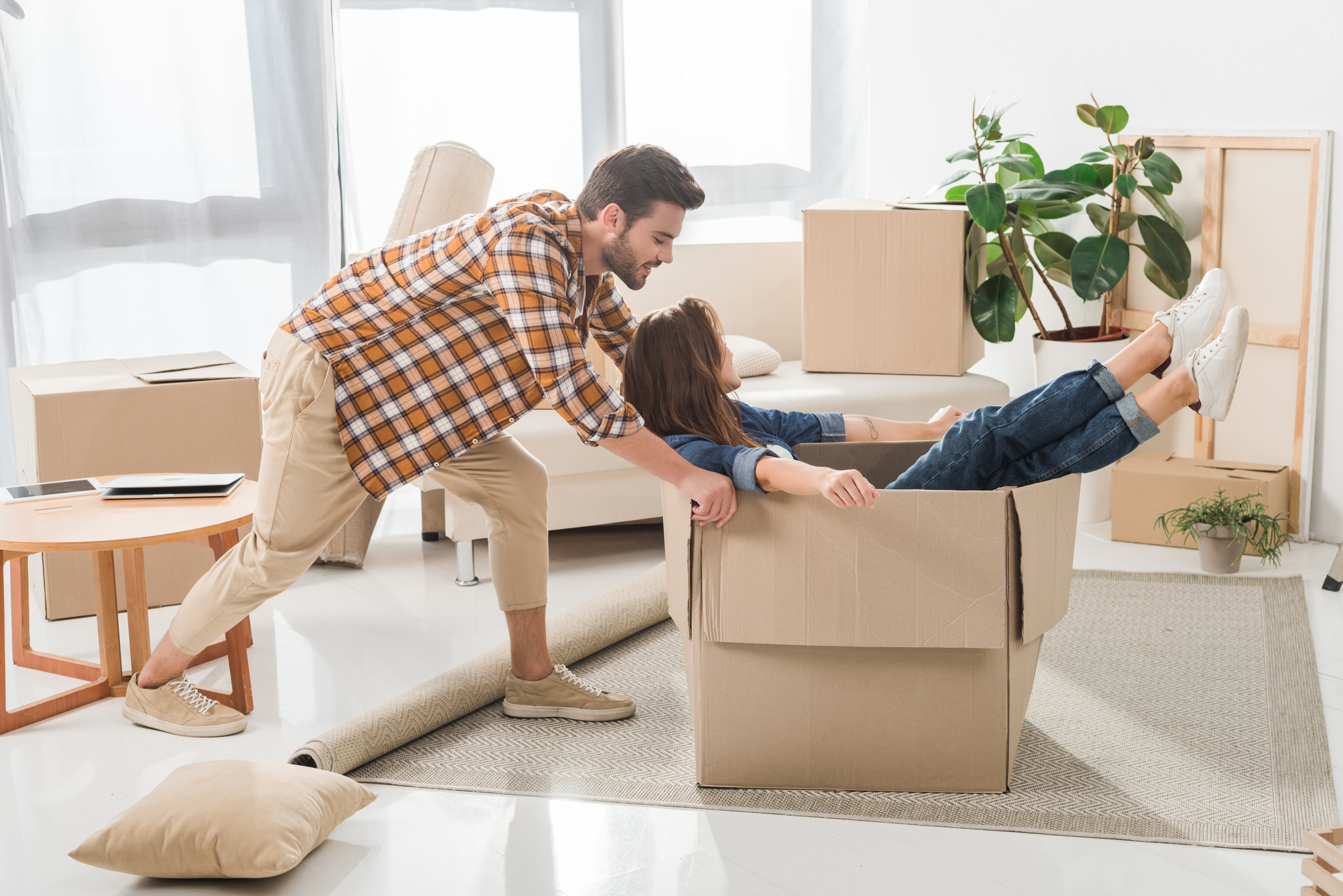Couple having fun in cardboard moving boxes